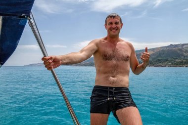 Lüks deniz gevşeme zevk shaka yelkenli üzerinde kayıt yapma yakışıklı mutlu bir adam portresi cruise. Yatçılık spor aktiviteleri ve yelken