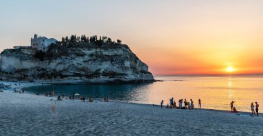 Tropea, İtalya - 27 Haziran 2017: Panorama görünümünü Tropea Beach yakınındaki büyük kayalar ve Santa Maria dell'Isola Kilisesi, Tropea, Calabria, İtalya. Deniz günbatımı Zamanı