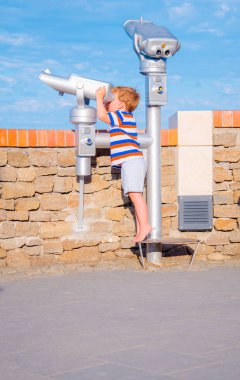 Çocuk teleskopla görünüyor