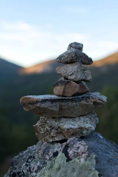 Pile of stones stacked on top of each other on the mountain at sunset