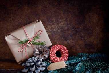 Çam kozalakları ve ladin dallarıyla süslenmiş Noel hediyesi. 