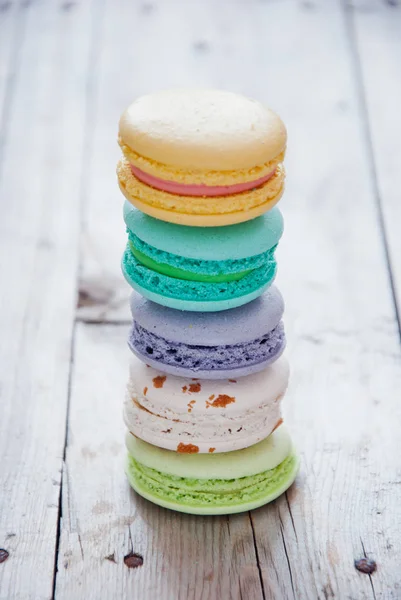 Pilha de macarons coloridos franceses em fundo de madeira cinza — Fotografia de Stock