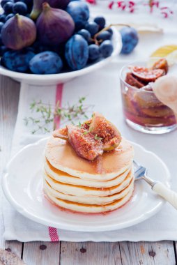 Beyaz tabakta incir reçelli ev yapımı krep yığını.