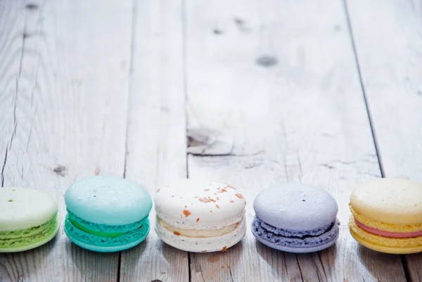 Macarons coloridos franceses em fundo de madeira cinza — Fotografia de Stock