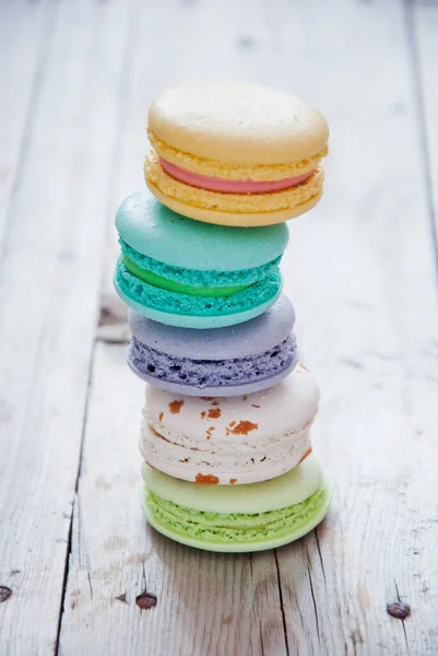 Pilha de macarons coloridos franceses em fundo de madeira cinza — Fotografia de Stock