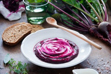 Kahverengi ahşap zemin üzerinde kremalı pancar çorbası