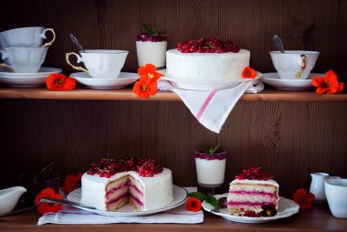 Taze kırmızı böğürtlen ve çiçeklerle süslenmiş üzümlü kekler.