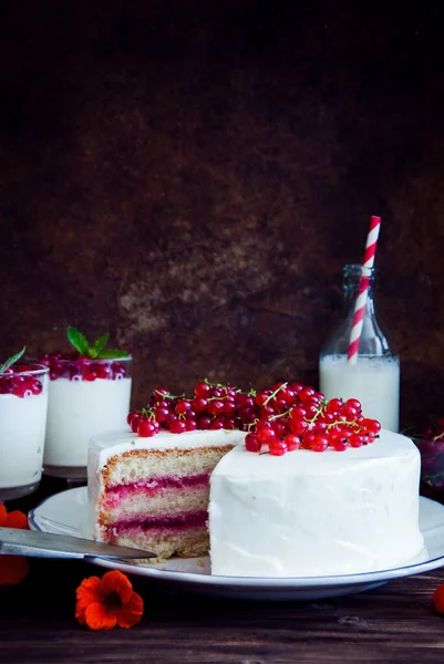 Cakes with red currant decorated with fresh red berries and flowers