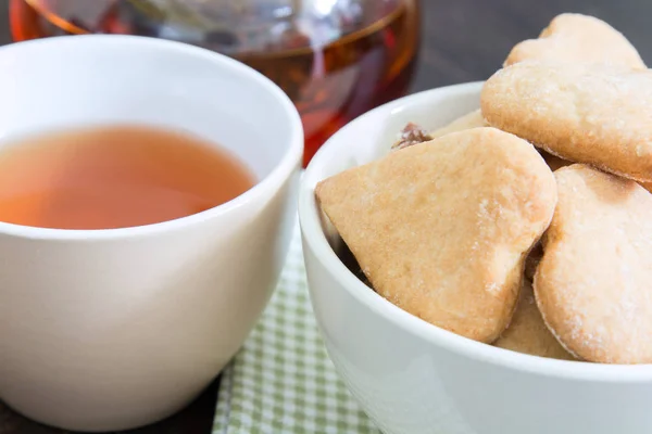 Bir fincan çay ve bir kase kahvaltı için çerezler ile