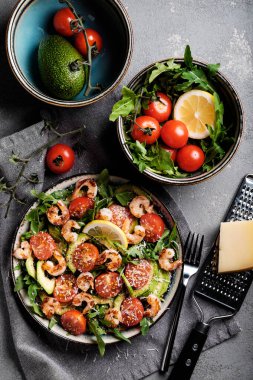 Kızarmış karides, domates, avokado, roka ve parmesanlı salata.