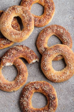 Gri arka planda susam tohumlarıyla pişirilmiş simitler.