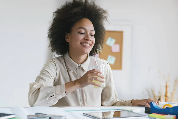 Junge lächelnde Geschäftsfrau arbeitet in ihrem Büro und tippt auf ihrem Laptop. — Stockfoto