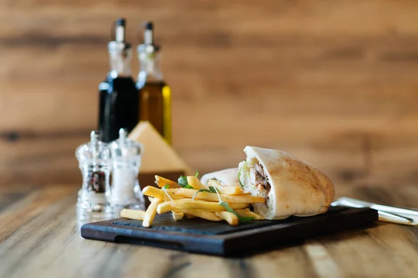 Sandwich et frites sur planche à découper — Photo