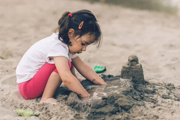 Kumsalda oynayan tatlı küçük kız. — Stok fotoğraf