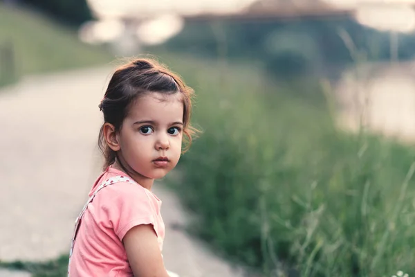 Malá dívka sedí na silnici — Stock fotografie