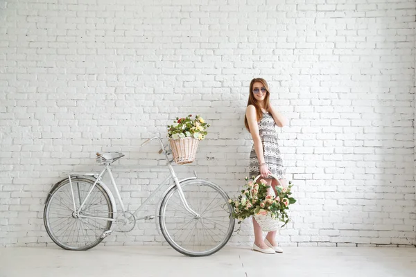 Portret van een gelukkig mooi jong meisje met vintage fiets en bloemen — Stockfoto