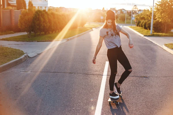 Jonge vrouw op de weg met een skateboard — Stockfoto