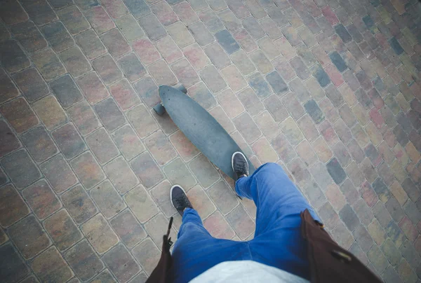Bovenaanzicht van benen in jeans en sneakers op skateboard — Stockfoto