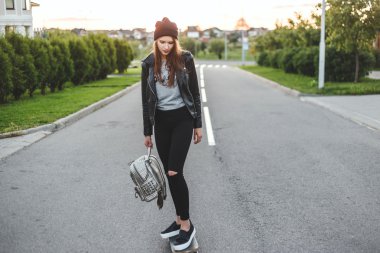 Güzel ve moda genç kadın bir kaykay üzerinde binmek