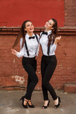 Mens tarzda giyinmiş iki mutlu kız flört.