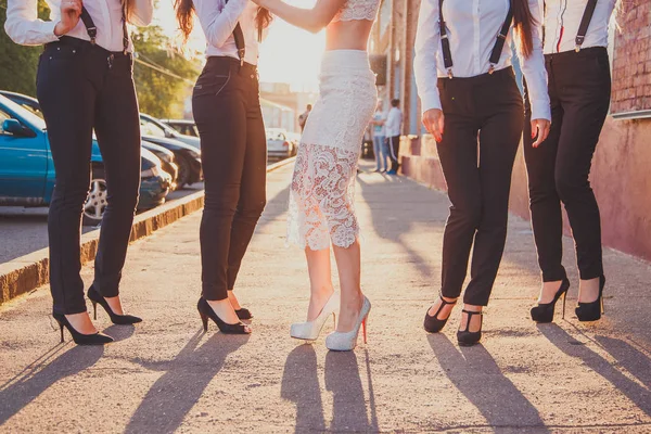 Beautiful legs of young girlfriends stylishly dressed in suits at hen-party. — Stock Photo, Image