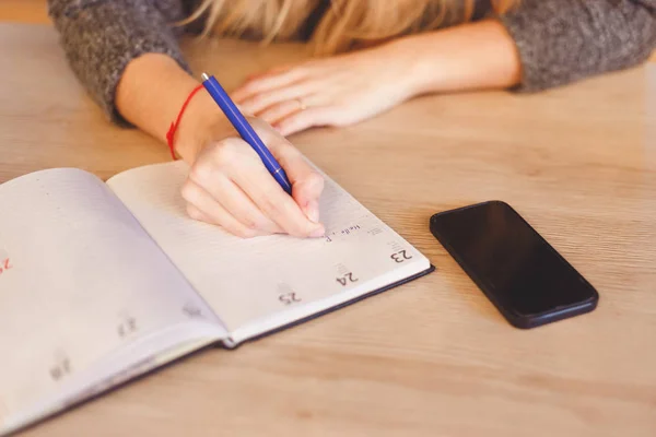 Крупним планом жіноча рука пише або підписується в документі на столі в домашньому офісі — стокове фото