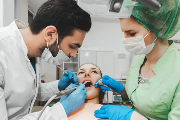 Młody utalentowany dentysta i jego asystent pielęgniarki w pracy — Zdjęcie stockowe