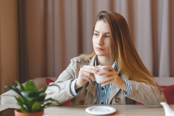 Mujer bebiendo té por la mañana en el restaurante de enfoque suave. Retrato de cerca de la chica bonita con taza — Foto de Stock