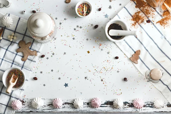 White table, strewn with candy powder and various holiday sweets around the center. Space for text. — Stock Photo, Image