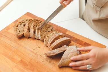 Kadın mutfakta bıçakla ekmek ciabatta kesme