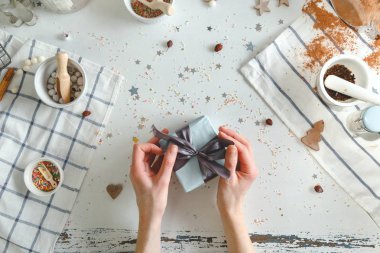 Kız Noel hediye kutusu ile mavi kurdele beyaz bir tablo paketleri. Üstten Görünüm.