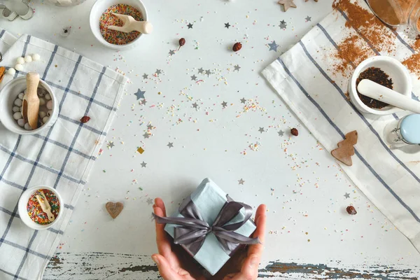 Woman holding in hands christmas present with blue ribbon. Holiday concept. Top view. — Stock Photo, Image