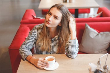 Genç güzel flört kadın bir kafede çay içer