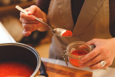 Baharat kız pişirme domates çorbası elinde kaşıkla yakın çekim.