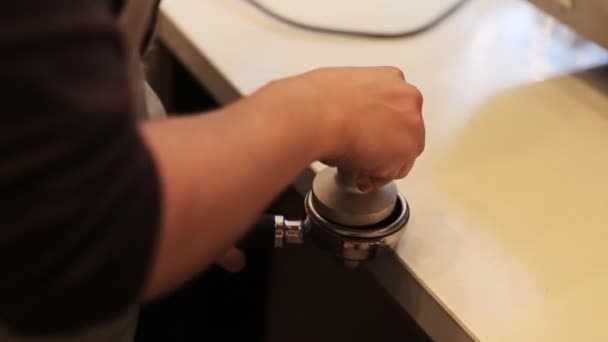 Professionell barista kockar malet kaffe i portafiltret och infogar den i kaffemaskinen. — Stockvideo