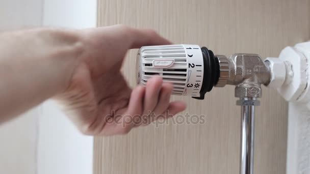 Close-up de uma mão de pessoas ajustando a temperatura do termostato do radiador — Vídeo de Stock