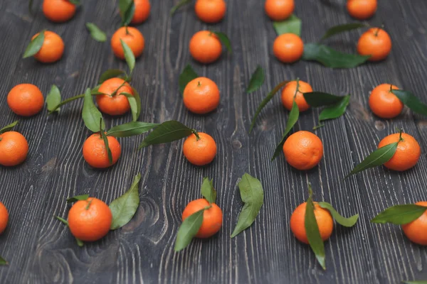 Beaucoup de mandarine orange ronde mûre en quelques rangées lisses sur fond de bois noir foncé — Photo