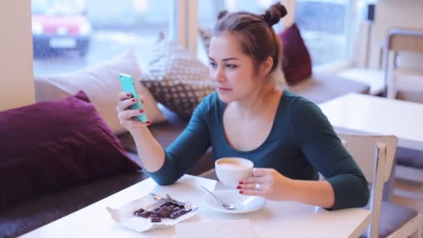 Жінка використовує мобільний телефон у кав'ярні — стокове відео