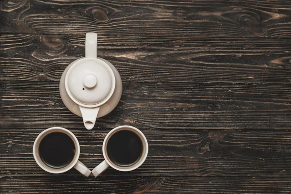 Dos tazas de té y tetera en mesa de madera loft de textura oscura . — Foto de Stock