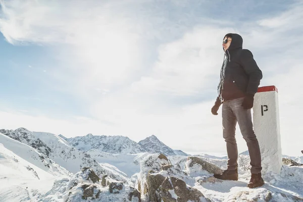 Retrato de un hombre vestido de invierno en pleno crecimiento en la cima de las montañas nevadas —  Fotos de Stock