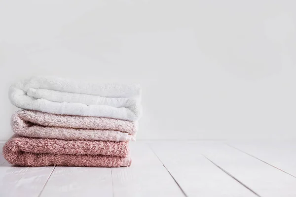 Montón de toallas limpias en la mesa de madera en el baño . — Foto de Stock