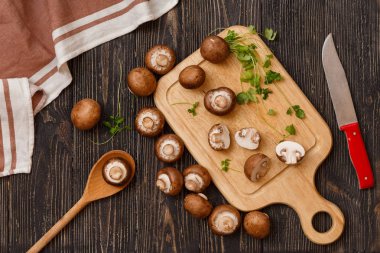 Taze fesleğen yaprakları ile ahşap kurullarında eski rustik arka plan üzerinde mantar. Üstten Görünüm, dikey kompozisyon.