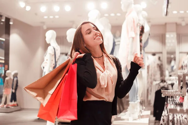 割引で幸せなファッション女性ファッション ブティックでカラフルなショッピング バッグを歓喜します。 — ストック写真