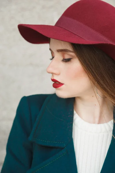 Young beautiful Woman Profile Portrait. Woman in a red hat on her head, Beautiful Face and soft Skin.
