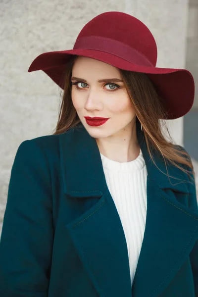 Portrait of young beautiful fashionable woman with long hair, trendy makeup. Model looking at camera, wearing stylish coat, pullover, hat. Female fashion, beauty concept. — Stock Photo, Image