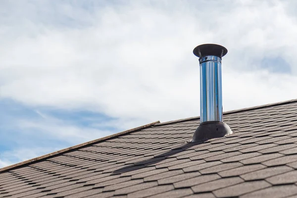 Tubo de chaminé de aço inoxidável no telhado da casa — Fotografia de Stock