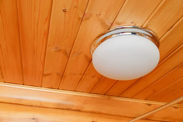 Lámpara blanca de cristal de techo en un techo de madera —  Fotos de Stock