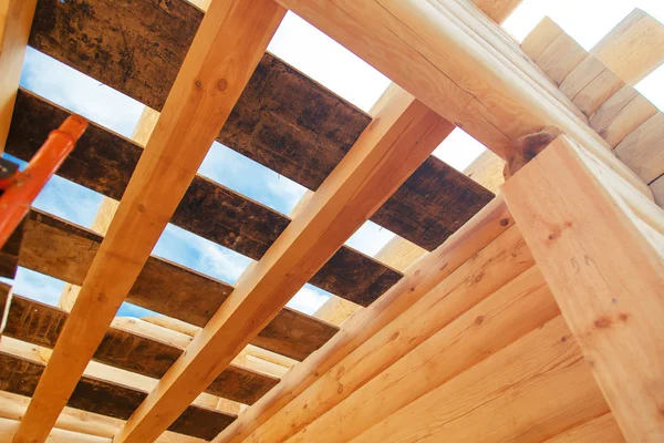 Vigas de madera contra el cielo azul en la casa en construcción . — Foto de Stock