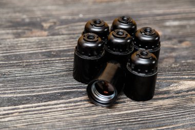 Siyah ahşap zemin üzerine ampul için plastik ve seramik elektrikli cartriges kümesi