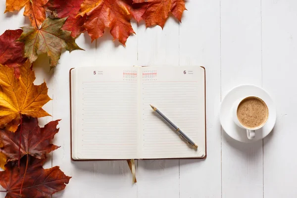 Het concept van herfst stemming. 'S ochtends koffie, dagboek en gekleurde esdoorn bladeren. Bovenaanzicht — Stockfoto